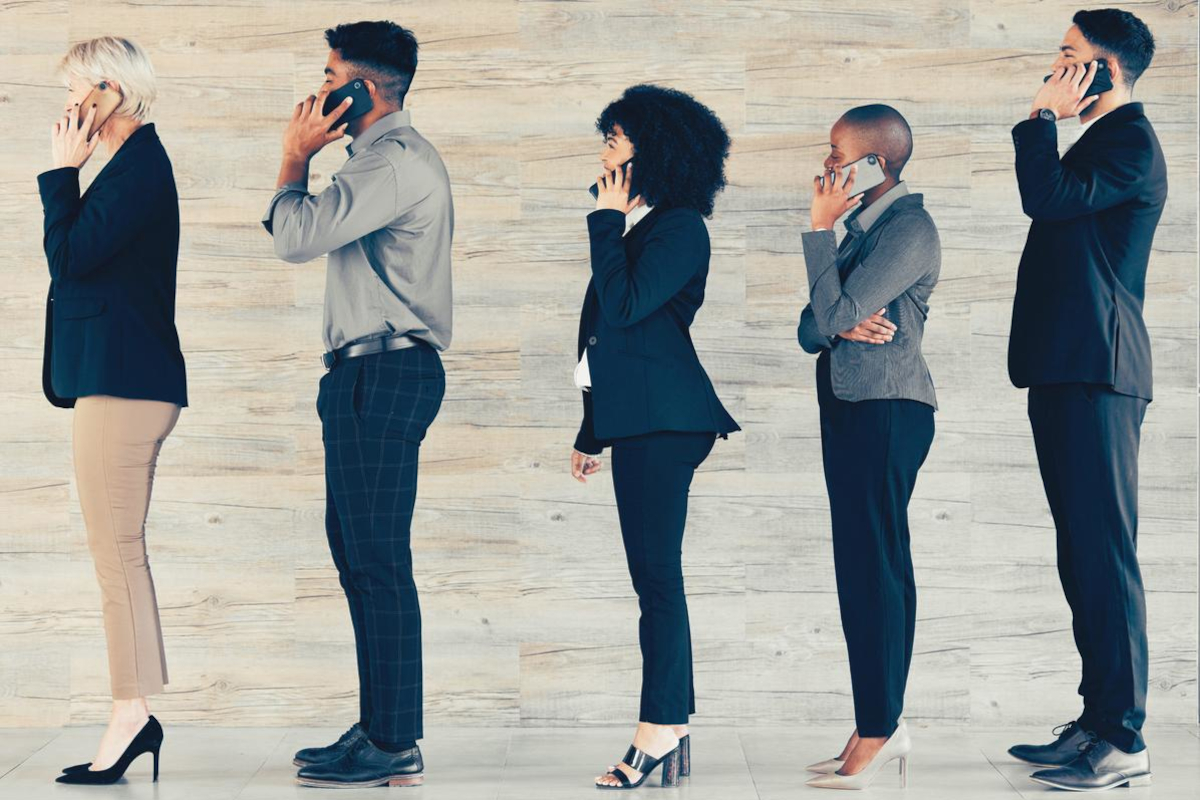 Business people line up talking on mobile phones.