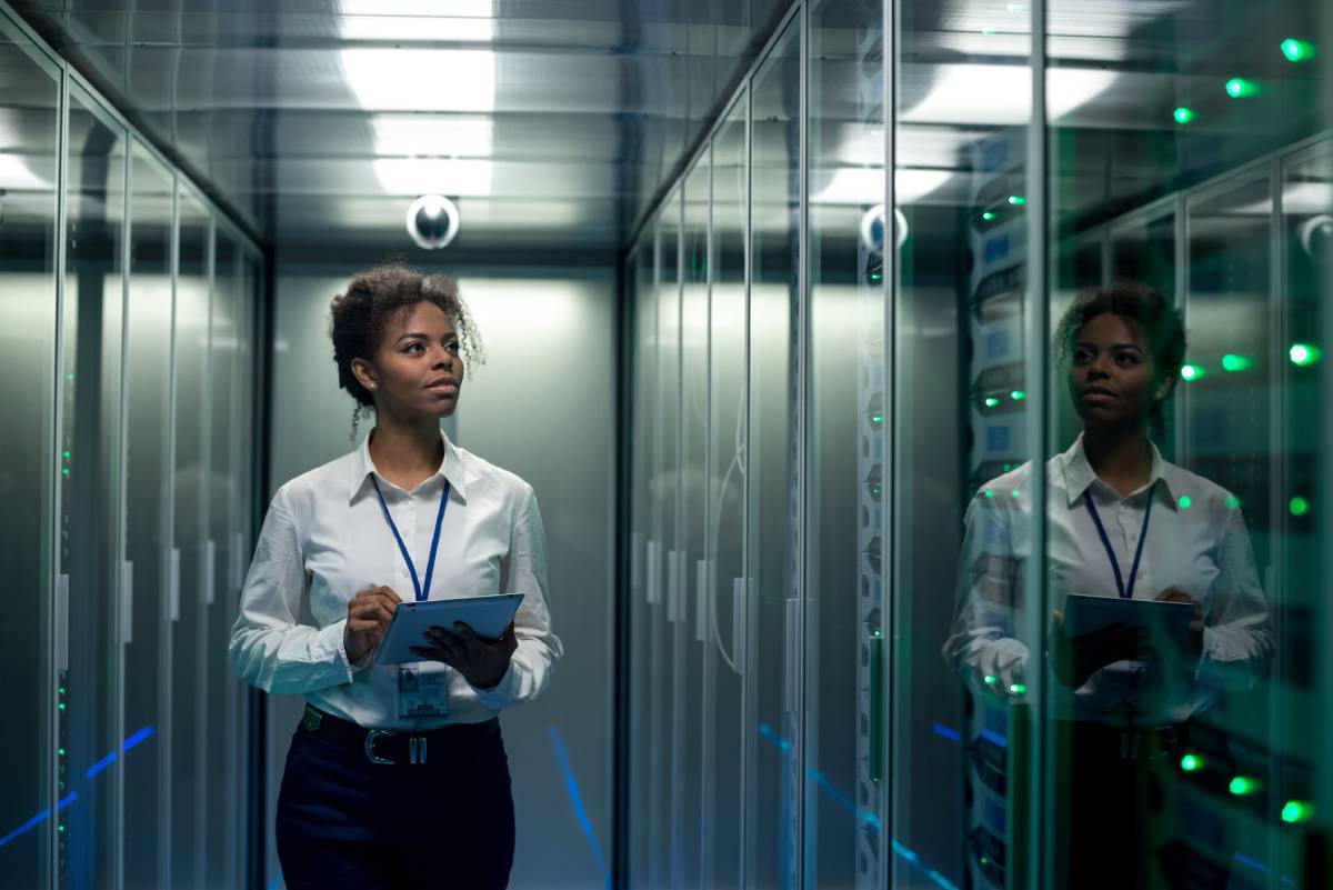 A woman using a tablet in a server room