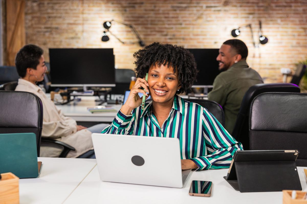 Office worker handling customer calls at a desk.