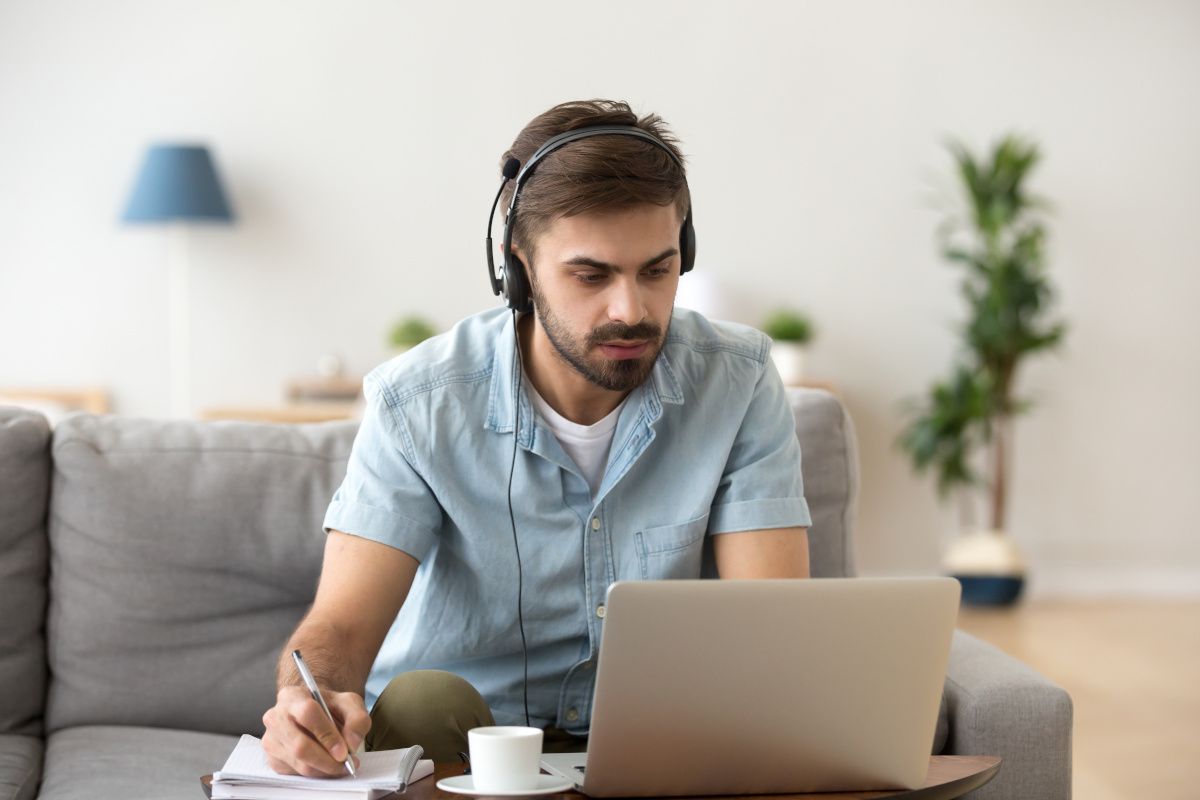 A remote worker taking notes during a phone call