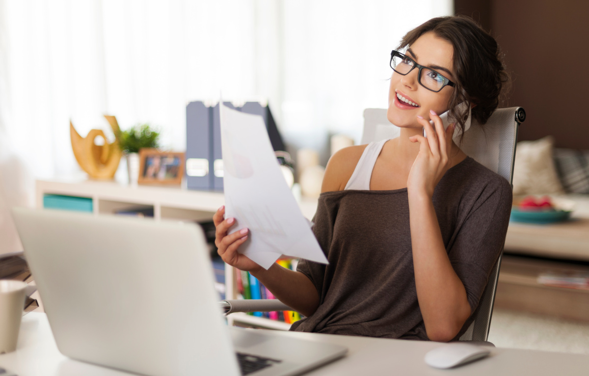 A woman working from home and talking on a phone